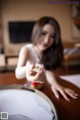 A woman sitting at a table holding a piece of paper.