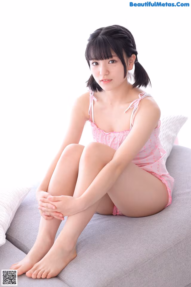 A woman sitting on a couch with her legs crossed.